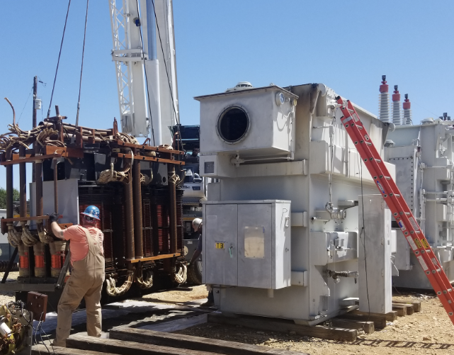 A worker from MCF Waukesha Transformers is working on a transformer in a field