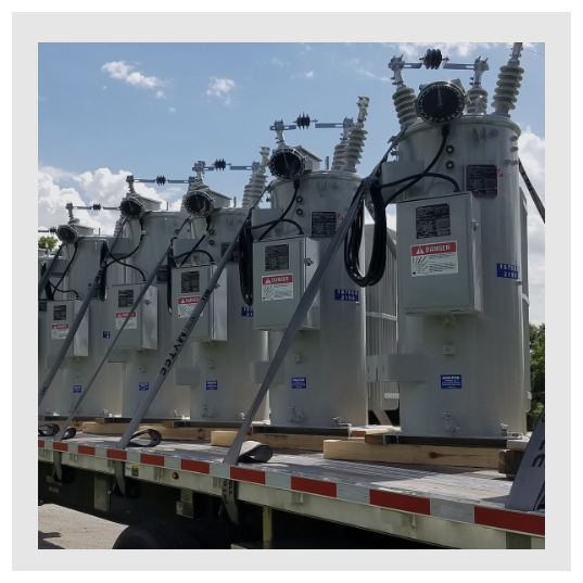 Voltage regulators and other electrical gear are loaded on a truck.