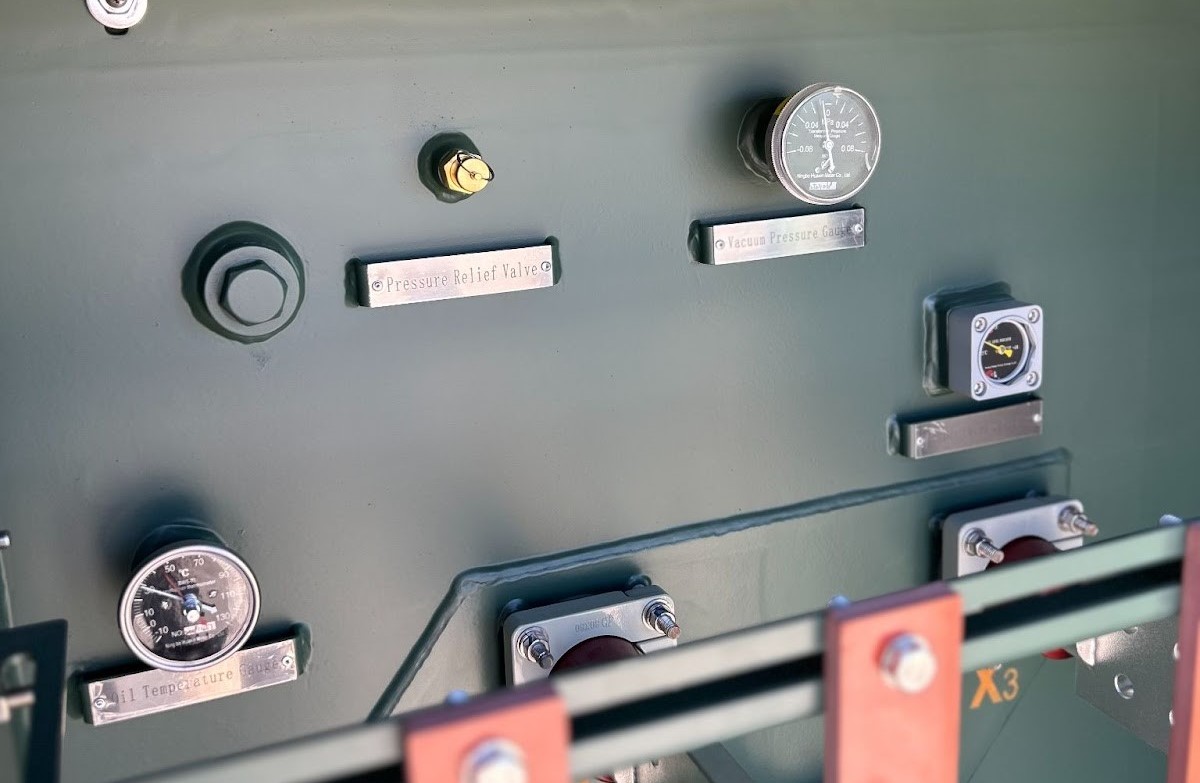 Green electrical panel with gauges for oil temperature and vacuum pressure,and a pressure relief valve.