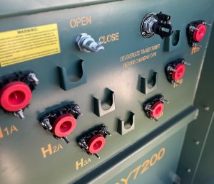 Green electrical transformer panel with labeled terminals(H1A, H2A,H3A)and an OPENCLOSE switch.